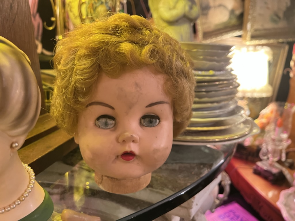 A scary broken doll head stares lifelessly