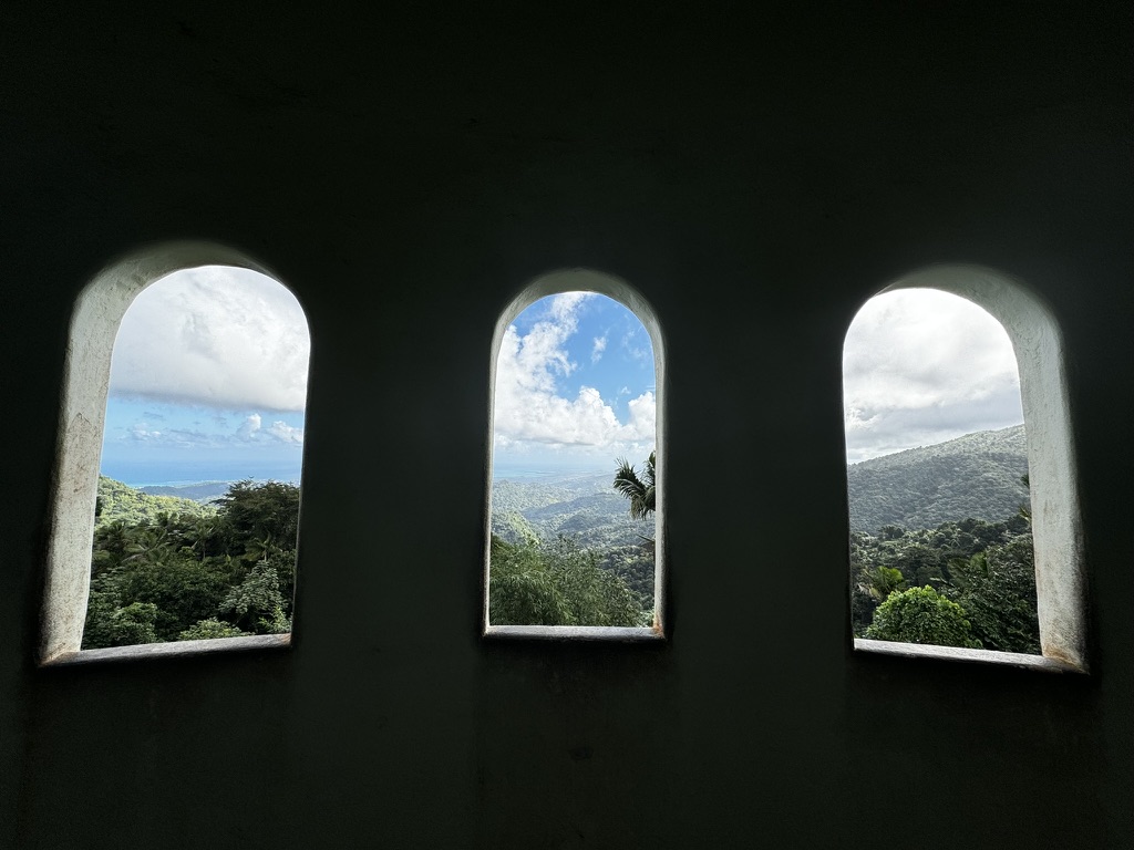 Beautiful expansive views from inside a tower with three windows that look out over the El Yunque rainforest and the ocean.